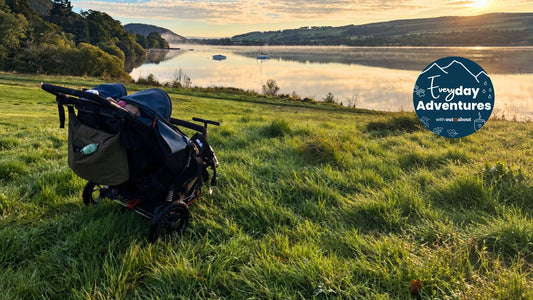 Nipper Double V6 buggy on grass beside a lake in golden sunlight, with the Everyday Adventures campaign badge.